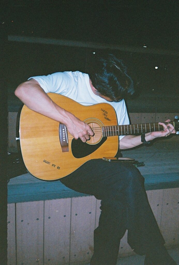 ギターの弾き方を教えてくれている友人の写真。